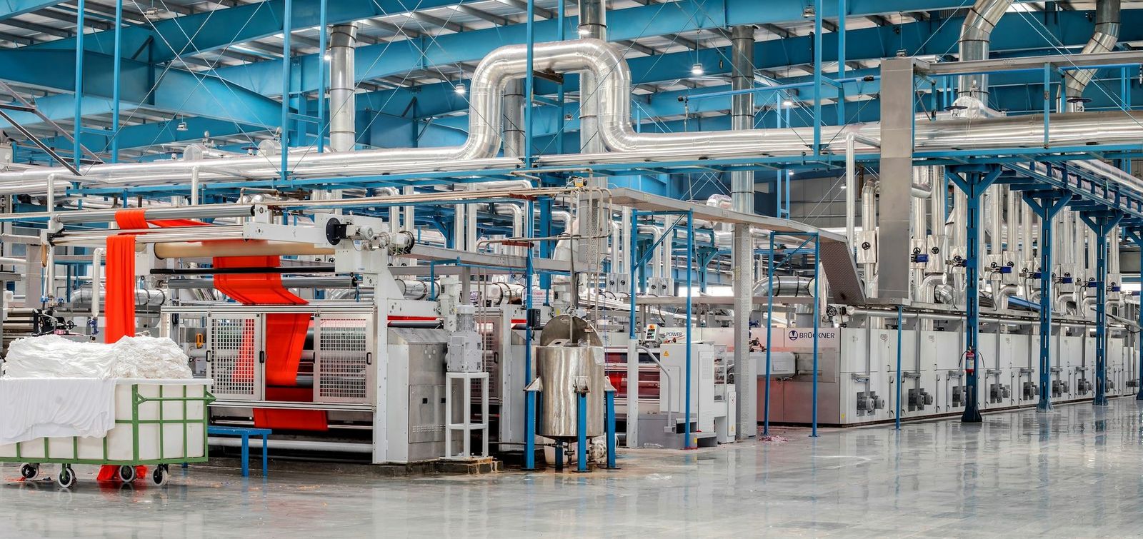 Plant floor with process machinery and overhead piping